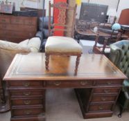 A 20th century oak pedestal desk with a leather inset top above a central drawer and two banks of