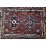 A red ground rug with twin medallions and multiple guard stripes