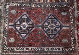 A red ground rug with twin medallions and multiple guard stripes