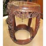 An early 20th century Chinese carved rosewood seat of barrel shape ornately carved and pierced with