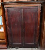 A 19th century mahogany bookcase with a moulded cornice above a pair of cupboard doors on gilt