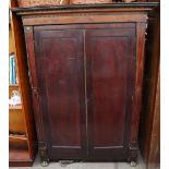 A 19th century mahogany bookcase with a moulded cornice above a pair of cupboard doors on gilt