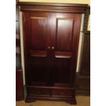 A 20th century mahogany wardrobe with a pair of cupboard doors and base drawers