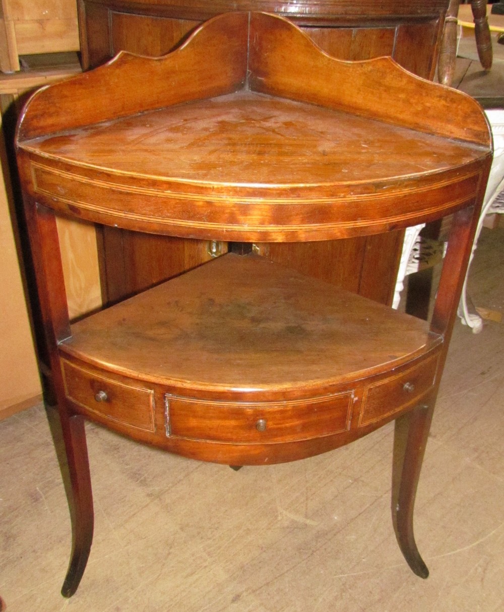 A George III mahogany corner washstand with cross banding and inlaid decoration having two tiers on