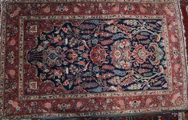 A Kashan prayer rug, the indigo mihrab hung with lantern, a vase below, amongst trees, flowers,