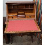 An early 20th century walnut bureau with a sloping fall and fitted interior