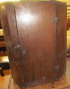 An 18th century oak hanging corner cupboard