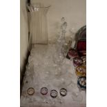 A pair of cut glass decanters together with a claret jug, drinking glasses, a large glass vase,