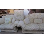 A pair of floral upholstered three seater settees together with a foot stool