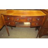 A late Regency mahogany bow front dressing table, having five drawers about a kneehole,