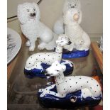 A pair of pottery figures of seated poodle type dogs,