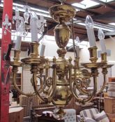 A brass five branch chandelier with scrolling arms