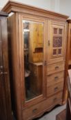 An Edwardian limed oak wardrobe with a mirrored door,