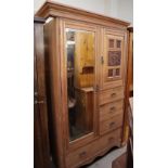 An Edwardian limed oak wardrobe with a mirrored door,