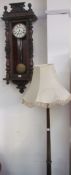 A Vienna regulator type wall clock together with a standard lamp,