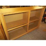 A modern oak display cabinet with sliding glass doors