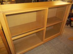 A modern oak display cabinet with sliding glass doors