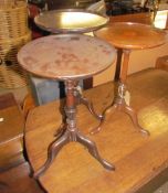 An Edwardian mahogany wine table with a central fan inlay on a turned column and three legs