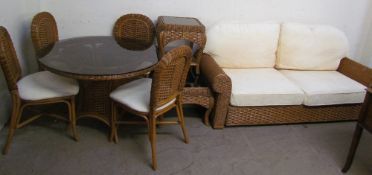 A conservatory suite comprising a glass topped dining table and four chairs together with a settee