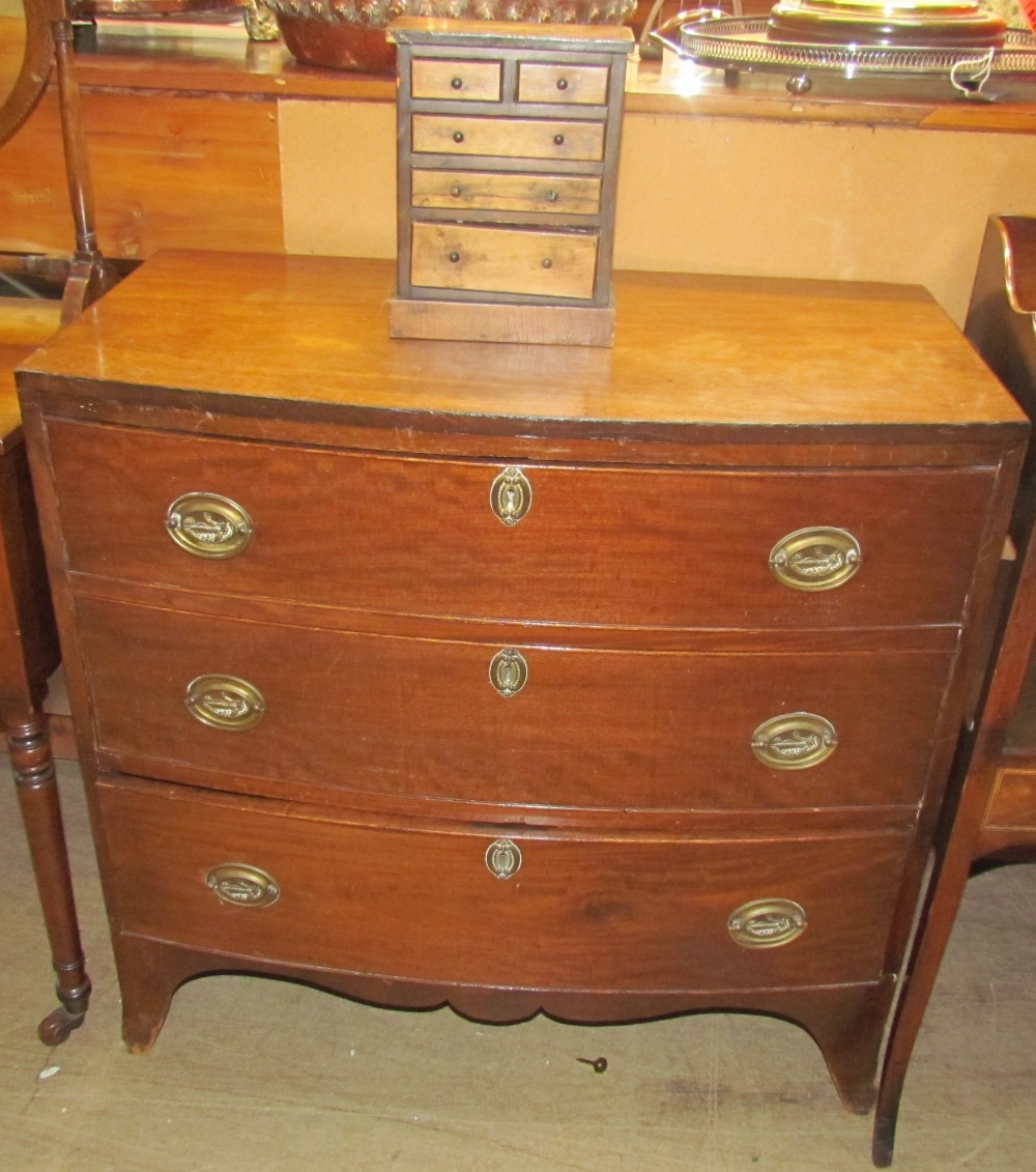 A George III mahogany chest, the D shaped top above three long drawers on splayed bracket feet,