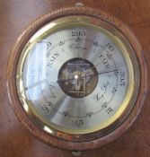 An oak cased aneroid barometer of circular form