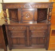 A 20th century oak court cupboard the rectangular top above a pair of drawers and a central