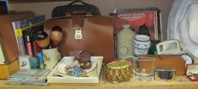 A brown leather briefcase together with a sewing machine, board games, stamps, records, foot warmer,