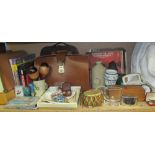 A brown leather briefcase together with a sewing machine, board games, stamps, records, foot warmer,