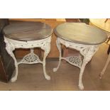 A pair of cast iron pub tables with circular wooden tops,