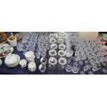A suite of crystal glasses together with glass storage jars, vases,