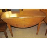 An oak drop leaf table of oval form,