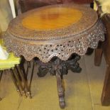 A Burmese carved hardwood occasional table on a carved tripod base