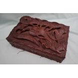 An Asian hardwood cigar box, carved with a Dragon in relief to the top,