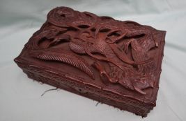 An Asian hardwood cigar box, carved with a Dragon in relief to the top,