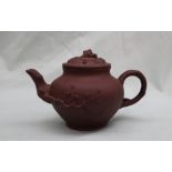 A Yixing pottery teapot, decorated with raised flowers and leaves,