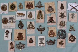 A collection of circa thirty two military cap badges including East Surrey, Duke of Lancasters Own,