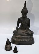 A bronze of a seated Buddha, on a cast base, 22cm high together with two smaller seated Buddhas, 6.