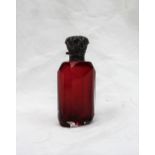 An Edwardian Silver topped and cranberry glass scent bottle, cast with leaves to a faceted body,