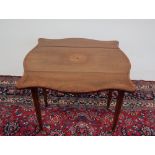 An Edwardian rosewood Pembroke table with a serpentine shaped top with drop flaps and a central