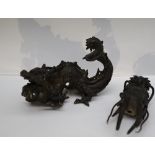 A Chinese bronze dragon, with gaping mouth and raised scrolling tail,