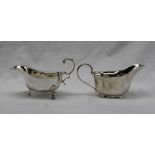 A George V silver sauce boat of cut rim form, flying double scroll leaf capped handle,