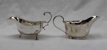 A George V silver sauce boat of cut rim form, flying double scroll leaf capped handle,