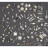 A large collection of white metal charms, including hats, dice, comb, scissors etc,