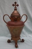 An ecclesiastical brass double spouted water jug, the domed cover with a cross atop,