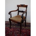 A late Regency carved oak elbow chair, the back bar with shell and flower heads, carved arms,