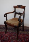 A late Regency carved oak elbow chair, the back bar with shell and flower heads, carved arms,