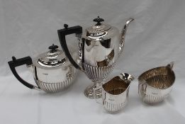 A George V silver four-piece tea and coffee set of oval bodied shape with some gadrooning,