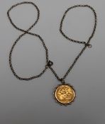 A George V gold half sovereign, dated 1915 in a yellow metal slip mount on a 9ct yellow gold chain,