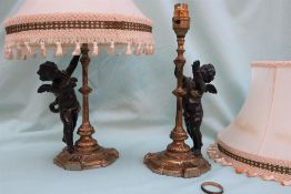 A pair of bronzed cherub table lamps,