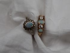 An opal and diamond ring set with three opals and two old round cut diamonds to an 18ct yellow gold